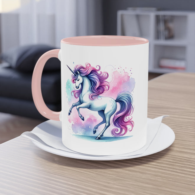 Tasse mit rosa Griff und Rand, dekoriert mit einer Einhorn-Illustration, stehend auf einem Holztisch vor einem Fenster